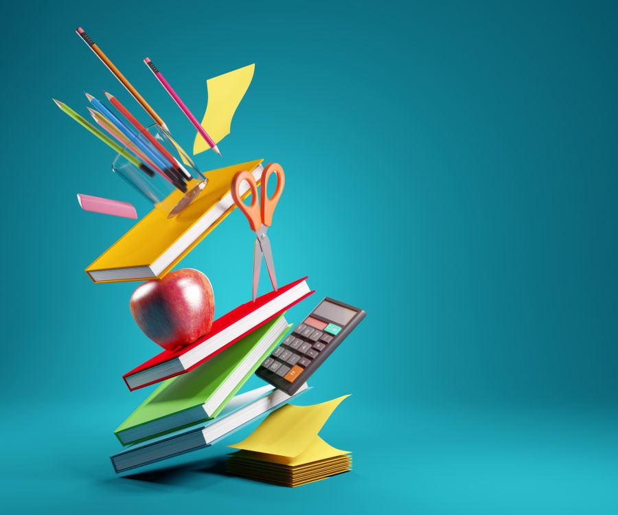 Image of notebooks, calendar, apple, scissors toppling sidewards