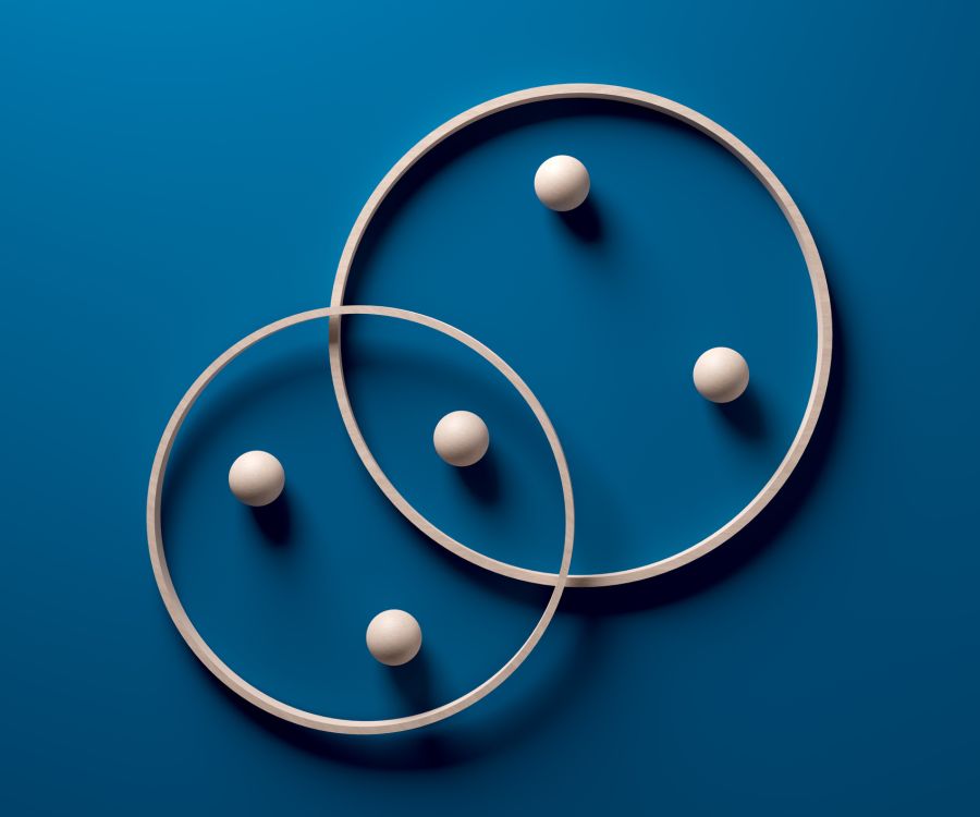 Two overlapping circles with three white spheres in each circle.