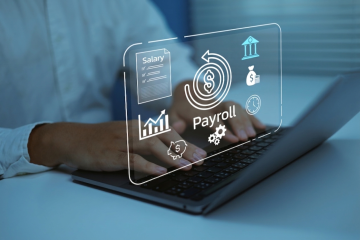 person typing on a laptop that says payroll